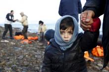 A Syrian refugee child looks on, moments after arriving on a raft with other Syrian refugees on a beach on the Greek island of Lesbos, January 4, 2016. PHOTO BY REUTERS/Giorgos Moutafis