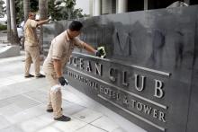 A worker cleans the site where the Trump name was removed from the Trump Ocean Club International Hotel and Tower in Panama City, Panama, March 5, 2018. PHOTO BY REUTERS/Carlos Lemos