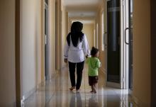 A counsellor and a recently rescued child walk together inside a state-run rehabilitation centre in Jakarta, Indonesia, April 4, 2016. PHOTO BY REUTERS/Darren Whiteside