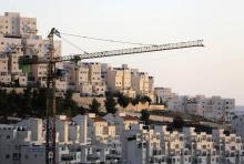 A crane is seen next to homes in a Jewish settlement near Jerusalem known to Israelis as Har Homa and to Palestinians as Jabal Abu Ghneim