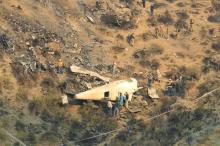 Rescue workers survey the site of a plane crashed a day earlier near the village of Saddha Batolni, near Abbotabad, Pakistan, December 8, 2016. PHOTO BY REUTERS/Faisal Mahmood
