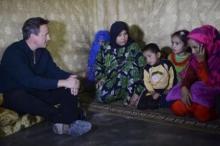 Prime Minister David Cameron meets a Syrian refugee family in a settlement camp in the Bekaa Valley in Lebanon, September 14, 2015. PHOTO BY REUTERS/Stefan Rousseau