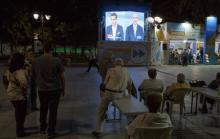 People watch a live televised debate between Former primer minister and leftist Syriza party leader Alexis Tsipras and the conservative New Democracy leader Vangelis Meimarakis, in Syntagma Square in the center of Athens, Greece, September 14, 2015. PHOTO BY REUTERS/Paul Hanna