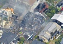 An aerial view shows debris of a crashed light plane (bottom C) and burning houses are seen after the plane went down in a residential area and burst into flames, in Chofu, outskirt of Tokyo, July 26, 2015. PHOTO BY REUTERS/Kyodo