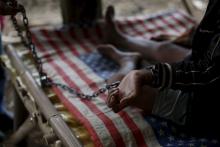 Deden, a teenager whose father says suffers from mental illness, lives chained to a tree under a shelter next to a rice paddy near his family home in Longkewang village in Serang, Banten province, Indonesia March 23, 2016. PHOTO BY REUTERS/Beawiharta
