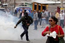 A demonstrator runs to throw a tear gas canister back to the police, during a protest against the re-election of Honduras' President Juan Orlando Hernandez in Tegucigalpa, Honduras January 20, 2018. PHOTO BY REUTERS/Jorge Cabrera