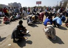 Demonstrators from the Jat community eat as they block the Delhi-Haryana national highway during a protest in New Delhi, India, February 21, 2016. PHOTO BY REUTERS/Adnan Abidi