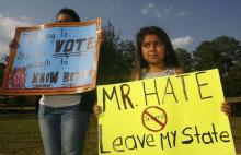 A young demonstrator holds up a sign protesting Republican presidential candidate Donald Trump down the street from a political campaign rally at the Valdosta State University Complex in Valdosta, Georgia, February 29, 2016. PHOTO BY REUTERS/Philip Sears