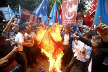 Demonstrators set fire to a Chinese flag during a protest against China near the Chinese Consulate in Istanbul, Turkey, July 5, 2015. PHOTO BY REUTERS/Osman Orsal