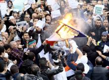 Demonstrators burn the French national flag after Friday prayers in Algiers, January 16, 2015. PHOTO BY REUTERS/Ramzi Boudina