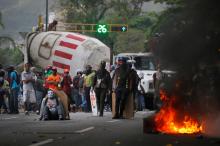 Demonstrators stand near a truck as they use it as a barricade while clashing with riot security forces during a rally called by healthcare workers and opposition activists against Venezuela's President Nicolas Maduro in Caracas. PHOTO BY REUTERS/Carlos Barria