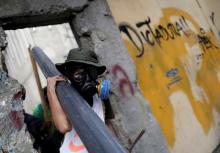 Demonstrators collect materials to build barricades while rallying against Venezuela's President Nicolas Maduro's government in Caracas, Venezuela, August 4, 2017. The graffiti on the wall reads "Dictatorship". PHOTO BY REUTERS/Ueslei Marcelino