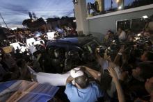 Demonstrators surround the vehicle transporting former Guatemalan Vice President Roxana Baldetti, as it arrives at a military hospital in Guatemala City, August 21, 2015. PHOTO BY REUTERS/Josue Decavele
