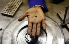 A Zimbabwean worker holds a piece of rough diamond from the country's Marange diamond fields, inside a polish and cutting shop in Harare, February 10, 2014. PHOTO BY REUTERS/Philimon Bulawayo