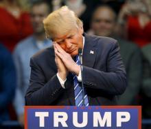 Republican presidential candidate Donald Trump gestures as if he is sleeping while talking about his opponent Jeb Bush during a Trump for President campaign rally in Raleigh, North Carolina, December 4, 2015. PHOTO BY REUTERS/Jonathan Drake
