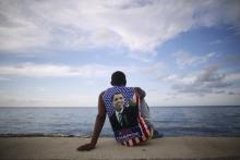 Medical student Electo Rossel, 20, wearing a shirt with a picture of U.S. President Barack Obama, listens to music at the Malecon seafront outside the U.S. embassy (not pictured) in Havana, Cuba, August 14, 2015. PHOTO BY REUTERS/Alexandre Meneghini