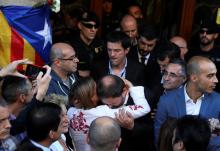 Catalan vice president Oriol Junqueras is embraced by president of Catalonian parliament Carme Forcadell outside the Catalan region's economy ministry building during a raid by Spanish police on government offices, in Barcelona, Spain, September 20, 2017. PHOTO BY REUTERS/Susana Vera