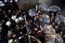 Employees block the door as riot police try to enter Kanalturk and Bugun TV building in Istanbul, Turkey, October 28, 2015. PHOTO BY REUTERS/Usame Ari