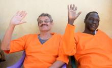 William John Endley, a South African national and adviser to South Sudanese rebel leader Riek Machar, and James Gatdet Dak, a former spokesman of the rebel leader, raise their hands as they sit inside the prison in Juba, South Sudan, November 2, 2018. PHOTO BY REUTERS/Jok Solomun