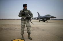 A U.S. soldier stands guard in front of their Air F-16 fighter jet at Osan Air Base in Pyeongtaek, South Korea, January 10, 2016. PHOTO BY REUTERS/Kim Hong-Ji