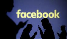 Silhouettes of mobile users are seen next to a screen projection of the Facebook logo in this picture illustration taken March 28, 2018. PHOTO BY REUTERS/Dado Ruvic/Illustration