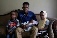 Aden Hussein Hassan with his daughter Asmo, 2 days, son Mohammed, 4, and daughter Adno, pose for a picture inside their apartment in Columbus, Ohio, U.S., August 8, 2018. PHOTO BY REUTERS/Shannon Stapleto