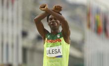 Feyisa Lilesa (ETH) of Ethiopia celebrates in the Final Men's Marathon ib Rio de Janeiro, Brazil, August, 21, 2016. PHOTO BY REUTERS/Athit Perawongmetha