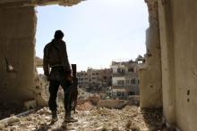 A rebel fighter stands on a damaged building near the frontline during what the rebel fighters called a battle to unite rebel factions against forces loyal to Syria's President Bashar al-Assad in Jobar, a suburb of Damascus, April 21, 2015. PHOTO BY REUTERS/Amer Almohibany