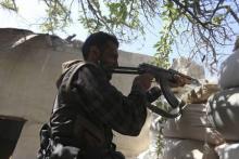 A fighter from the Free Syrian Army's Al Rahman legion fires his weapon on the frontline against the forces of Syria's President Bashar al-Assad in Jobar, a suburb of Damascus, Syria, July 27, 2015. PHOTO BY REUTERS/Bassam Khabieh