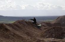 A rebel fighter from the Ahrar al-Sham Islamic Movement takes a position as he aims his weapon at Morek front line in the northern countryside of Hama, March 16, 2015. PHOTO BY REUTERS/Khalil Ashawi