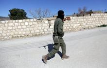 A Turkish-backed Free Syrian Army fighter holds a weapon as he walks north of Afrin, Syria, March 17, 2018. PHOTO BY REUTERS/Khalil Ashawi