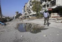 A rebel fighter walks in Babila town, during what activists said was a new ceasefire between forces loyal to Syria's president Bashar Al-Assad and rebel fighters in the towns of Babila and Beit-Sahm in southeast Damascus, January 14, 2015. PHOTO BY REUTERS/Stringer