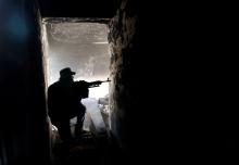 A fighter of Libyan forces allied with the U.N.-backed government aims his weapon as he takes up position inside a ruined house at the front line of fighting with Islamic State militants in Ghiza Bahriya district in Sirte, Libya, November 9, 2016. PHOTO BY REUTERS/Ismail Zitouny