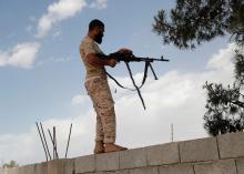 A member of the Libyan internationally recognised government fires a rifle at outskirts of Tripoli, Libya, May 12, 2019. PHOTO BY REUTERS/Goran Tomasevic