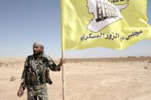 A fighter from Deir al-Zor military council which fights under the Syrian Democratic Forces (SDF) holds the council's flag in the village of Abu Fas, Hasaka province, Syria, September 9, 2017. PHOTO BY REUTERS/Rodi Said