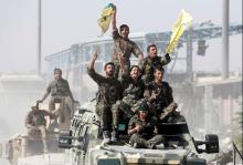 Syrian Democratic Forces (SDF) fighters ride atop of military vehicles as they celebrate victory in Raqqa, Syria, October 17, 2017. PHOTO BY REUTERS/Erik De Castro