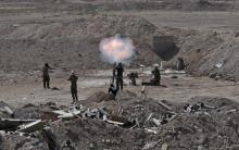 Members of the Iraqi army and Shi'ite fighters launch a mortar toward Islamic State militants outskirt the city of Falluja, Iraq, May 19, 2015. PHOTO BY REUTERS/Stringer