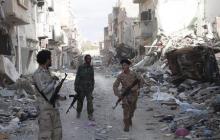 Members of Libyan pro-government forces, backed by the locals, walk with weapons during clashes in the streets with Shura Council of Libyan Revolutionaries, an alliance of former anti-Gaddafi rebels who have joined forces with Islamist group Ansar al-Sharia, in Benghazi, April 1, 2015. PHOTO BY REUTERS/Stringer