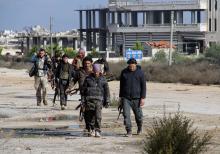 Rebel fighters walk around al-Hamidiyeh base, one of two military posts they took control of from forces loyal to Syria's President Bashar al-Assad in the northwestern province of Idlib, December 15, 2014. PHOTO BY REUTERS/Stringer