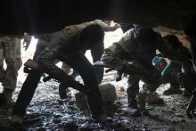 Free Syrian Army fighters enter a cave after what they said was a barrel bomb dropped by forces loyal to Syria's President Bashar al-Assad near Tal Meleh village in Hama countryside May 12, 2015. PHOTO BY REUTERS/Mohamad Bayoush