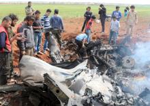 Rebel fighters and civilians gather around the wreckage of a Syrian warplane that was shot down in the Talat al-Iss area, south of Aleppo, Syria, April 5, 2016. PHOTO BY REUTERS/Ammar Abdullah