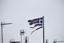 A frayed Greek national flag flutters among antennas atop a building in central Athens, Greece, July 20, 2015. PHOTO BY REUTERS/Alkis Konstantinidis