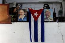 The Cuban flag hangs next to the photographs of late Cuba's President Fidel Castro and his brother, Cuba's former President Raul Castro, in Havana, Cuba, July 21, 2018. PHOTO BY REUTERS/String