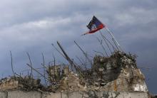 A flag of the self-proclaimed Donetsk People's Republic is seen at the top of damaged war memorial at Savur-Mohyla, a hill east of the city of Donetsk