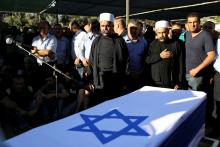 Members of the Druze community stand next to the flag-drapped coffin of Israeli Druze police officer Kamil Shanan during his funeral in the village of Hurfeish, Israel, July 14 2017. PHOTO BY REUTERS/Ammar Awad