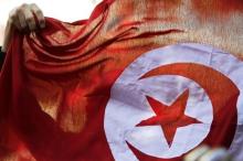 A person holds up a Tunisian flag and shouts slogans during celebrations marking the fourth anniversary of Tunisia's 2011 revolution, in Habib Bourguiba Avenue in Tunis, January 14, 2015. PHOTO BY REUTERS/Anis Mili