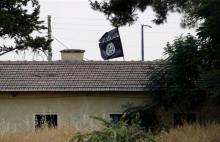 An Islamic State flag flies over the custom office of Syria's Jarablus border gate as it is pictured from the Turkish town of Karkamis, in Gaziantep province, Turkey in this August 1, 2015 file photo. PHOTO BY REUTERS/Murad Sezer
