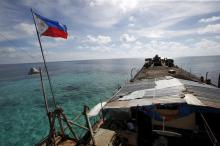 A Philippine flag flutters from BRP Sierra Madre, a dilapidated Philippine Navy ship that has been aground since 1999 and became a Philippine military detachment on the disputed Second Thomas Shoal, part of the Spratly Islands, in the South China Sea, March 29, 2014. PHOTO BY REUTERS/Erik De Castro