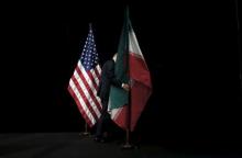 A staff member removes the Iranian flag from the stage after a group picture with foreign ministers and representatives of Unites States, Iran, China, Russia, Britain, Germany, France and the European Union during the Iran nuclear talks at the Vienna International Center in Vienna, Austria July 14, 2015. PHOTO BY REUTERS/Carlos Barria