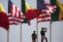 American security officers scan the airport from a rooftop below Senegalese and American flags before the departure of U.S. President Barack Obama in Dakar, Senegal, June 28, 2013. PHOTO BY REUTERS/Joe Penney